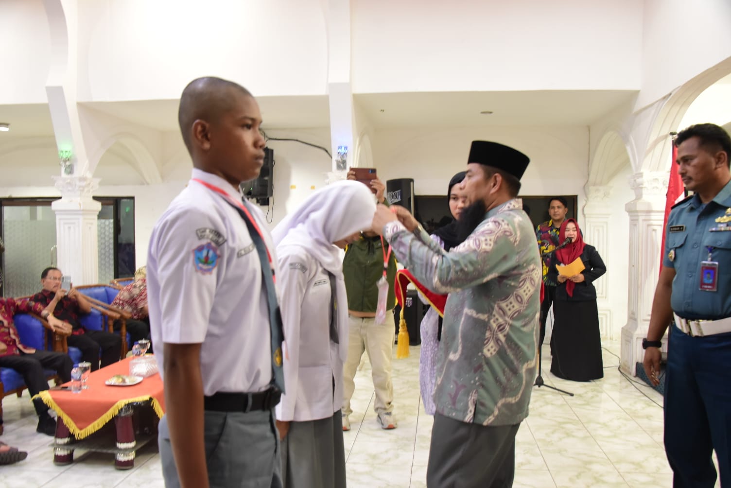 Asisten Pemerintahan dan Kesejahteraan Rakyat Kabupaten Bengkalis Andris Wasono memasangkan plakat kepada pelajar calon anggota Paskibraka