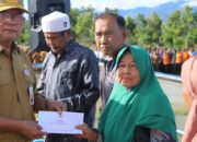 Sekda Kerinci Zainal Efendi, SP., M.Si, menyerahkan bantuan program Kerinci Pedulikepada sejumlah masyarakat penerima, di sela-sela apel kerja ASN. | Foto: Ist