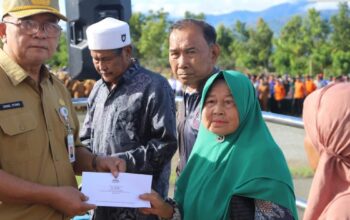 Sekda Kerinci Zainal Efendi, SP., M.Si, menyerahkan bantuan program Kerinci Pedulikepada sejumlah masyarakat penerima, di sela-sela apel kerja ASN. | Foto: Ist