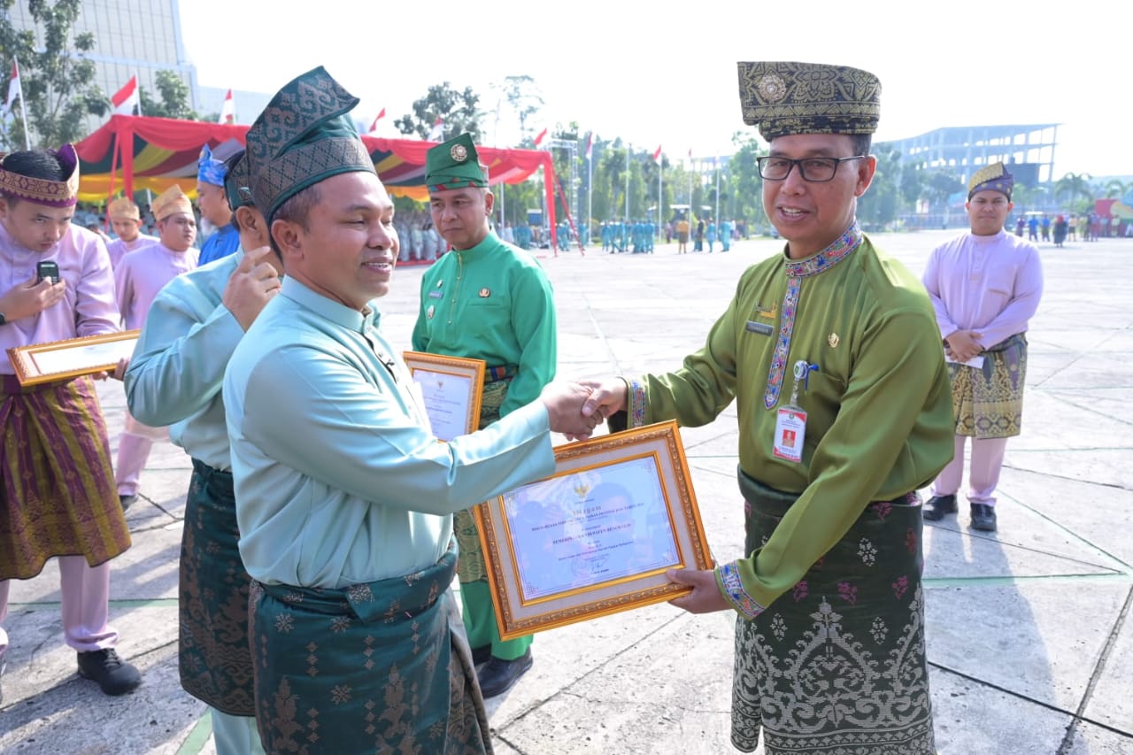 Gubernur Riau Abdul Wahid menyerahkan plakat kepada Asisten Perekonomian dan Pembangunan Sekretariat Daerah Kabupaten Bengkalis, Toharuddin dalam rangka HUT Riau ke-68